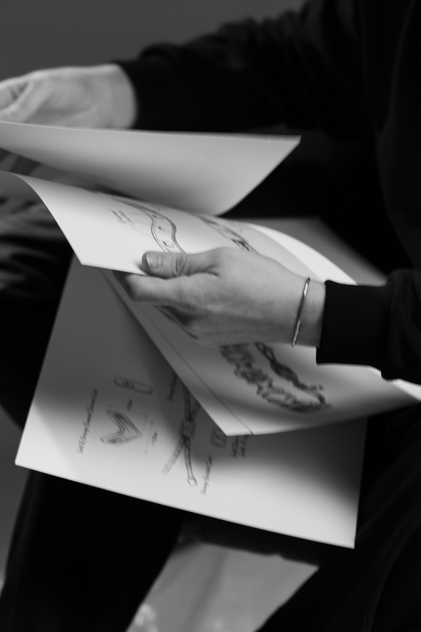 Hands leafing through design sketches